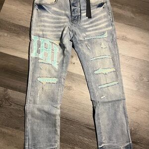 AMIRI Light Blue Distressed Jeans with Teal Patch